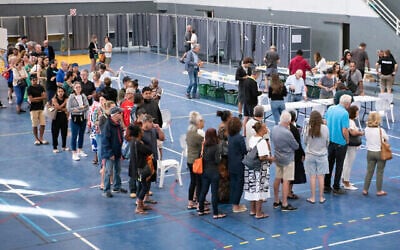 Des gens font la queue devant les bureaux de vote de la salle de sport de l'Anse Vata pour voter au premier tour des élections législatives françaises cruciales à Nouméa, dans le territoire français du Pacifique de la Nouvelle-Calédonie, le 30 juin 2024. (Crédit : Delphine MAYEUR / AFP)