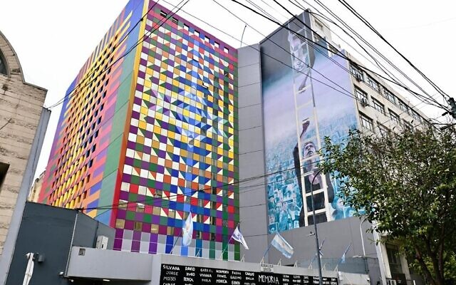 La nouvelle façade haute en couleurs du centre juif de l'AMIA, à Buenos Aires, jouxte une fresque peinte pour commémorer l'attentat à la bombe qui, en 1994, avait tué 85 personnes. (Crédit : TJuan Melamed/JTA) La nouvelle façade haute en couleurs du centre juif de l'AMIA, à Buenos Aires, jouxte une fresque peinte pour commémorer l'attentat à la bombe qui, en 1994, avait tué 85 personnes. (Crédit : TJuan Melamed/JTA)