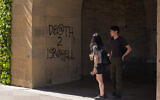 Des étudiants passent devant un graffiti disant "Mort à Israël" près du bureau du président de l'université de Stanford à Palo Alto, en Californie, le 5 juin 2024. (Crédit : AP Photo/Nic Coury)