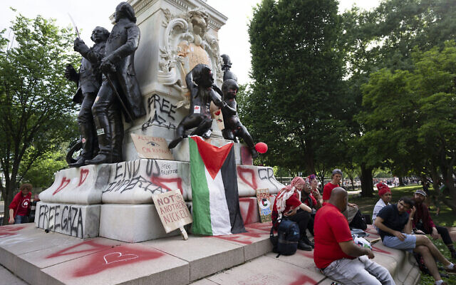 Un groupe de manifestants au pied de la statue vandalisée du général français Marquis de Lafayette à la fin d'une manifestation anti-israélienne et pro-palestinienne devant la Maison Blanche à Washington, le 8 juin 2024. (Crédit : AP Photo/Manuel Balce Ceneta)