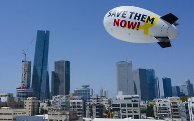 Proches et amis d'otages de Gaza ont fait voler un dirigeable demandant leur libération dans le ciel de Tel Aviv, le 9 juin 2024. (Crédit : AP Photo/Ariel Schalit)