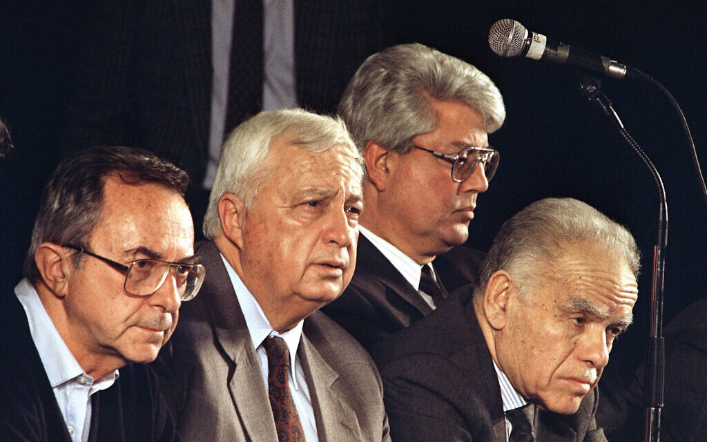 Les dirigeants du Likud, le parti au pouvoir en Israël, de gauche à droite, le ministre de la Défense Moshe Arens, le ministre du Logement Ariel Sharon, le ministre des Affaires étrangères David Levy et le Premier ministre Yitzhak Shamir assis lors de la première des trois conventions du parti Likud destinées à classer les candidats du Likud pour les prochaines élections israéliennes de juin, à Tel Aviv, le 10 février 1992. (Crédit : Nati Harnik/AP)