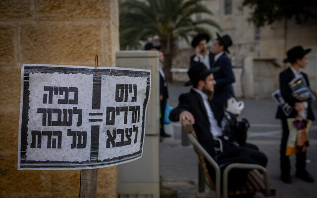 Un panneau s'opposant au recrutement des Juifs ultra-orthodoxes dans l'armée israélienne dit "la conscription militaire des Haredim - une transgression forcée de la religion", photo prise le 2 juin 2024. (Crédit : Chaim Goldberg/Flash90)
