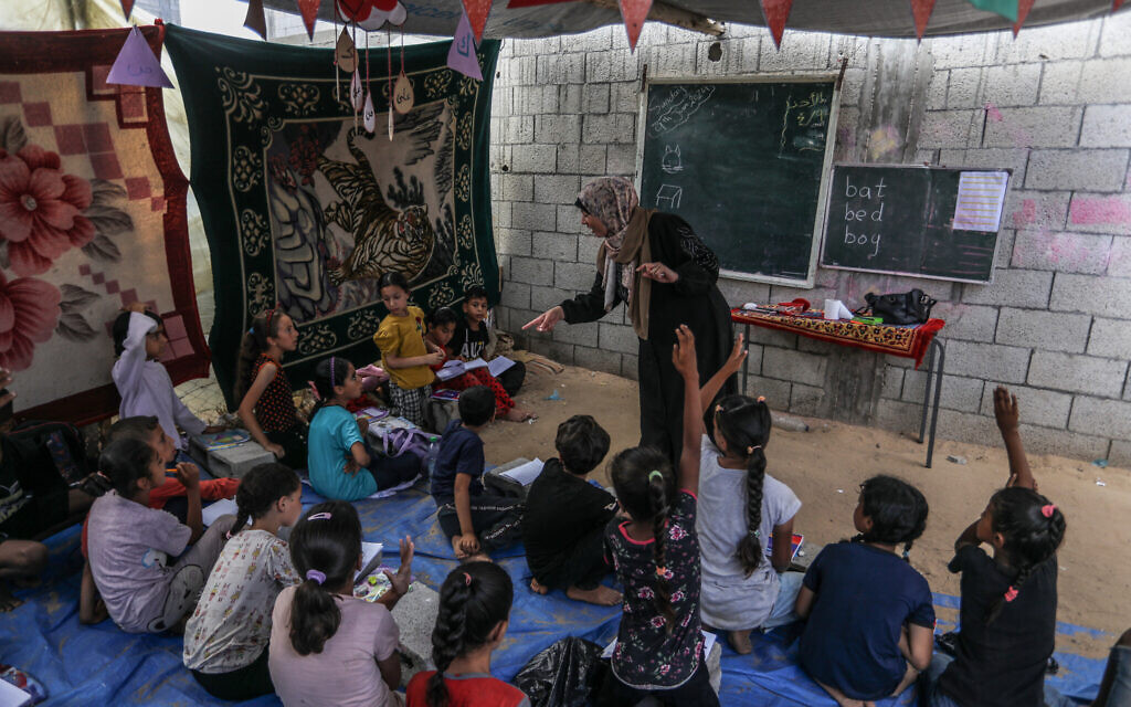 Des enfants palestiniens apprennent l'anglais dans une école temporaire de Deir al-Balah, dans le centre de la bande de Gaza, le 9 juin 2024. (Crédit : Abed Rahim Khatib/Flash90)