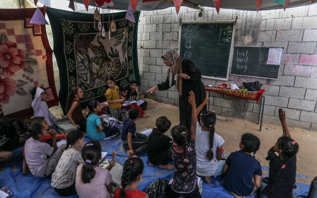 Des enfants palestiniens apprennent l'anglais dans une école temporaire de Deir al-Balah, dans le centre de la bande de Gaza, le 9 juin 2024. (Crédit : Abed Rahim Khatib/Flash90)
