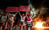 Les manifestants allument un feu aux abords de la Histadrut, appelant à la grève générale pour presser le gouvernement actuel et le Premier ministre Benjamin Netanyahu de conclure un accord visant à libérer les Israéliens encore détenus en otage dans la bande de Gaza à Tel Aviv, le 29 juin 2024. (Crédit : Jamal Awad/Flash90)