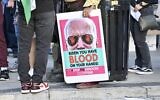 Un panneau à l'effigie de Joe Biden avec l'inscription "Biden, tu as du sang sur les mains, Stop le génocide !" tenu par un manifestant aux abords du Peacock Theater de Los Angeles. (Capture d'écran : X)