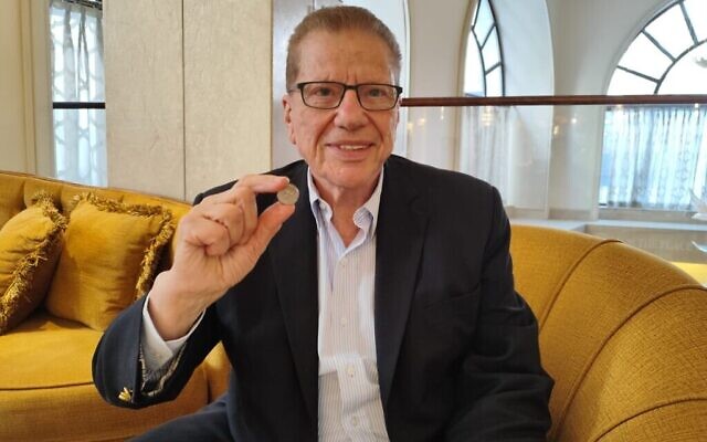 Le philanthrope George S. Blumenthal montre un shekel en argent de l'époque du Second Temple, dans les locaux de l'hôtel Waldorf-Astoria de Jérusalem, le 20 mai 2024. (Crédit : Gavriel Fiske/Times of Israel)