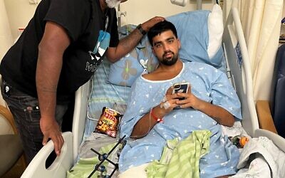 Le superintendant de la police Eyal Aharon rend visite à Shaked, son fils, à l'hôpital, alors qu'il est soigné pour des blessures essuyées au kibboutz Reïm le 7 octobre 2023. (Crédit : Autorisation)