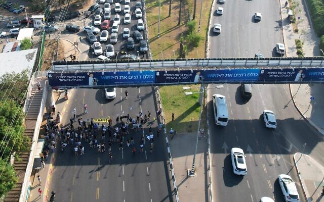 Des manifestants réclamant un accord pour libérer les otages détenus par les terroristes du Hamas dans la bande de Gaza bloquant le carrefour Kfar HaYarok, à Tel Aviv, le 5 juin 2024. (Crédit : Eitan Slonim/Mouvement de protestation pour la démocratie) Des manifestants réclamant un accord pour libérer les otages détenus par les terroristes du Hamas dans la bande de Gaza bloquant le carrefour Kfar HaYarok, à Tel Aviv, le 5 juin 2024. (Crédit : Eitan Slonim/Mouvement de protestation pour la démocratie)