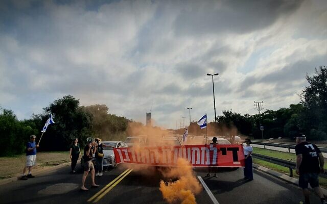 Des manifestants anti-gouvernement bloquent la Route 2 près de l'intersection Glilot lors d'une manifestation réclamant des élections, le 24 juin 2024. (Crédit : Udi Salmanovich/Mouvement de protestation pro-démocratie)