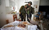 Des soldats de l'unité Lotar pleurant à la vue de la maison du kibboutz Kfar Aza qui avait encore le challah du repas familial de Shabbat de la veille sur la table lorsqu'elle a été attaquée par des terroristes du Hamas le 7 octobre,  le 10 octobre 2023. (Crédit : Ziv Koren/Polaris)
