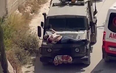 Des soldats israéliens accrochent un détenu palestinien au capot d'une voiture après une opération en Cisjordanie, le 22 juin 2024. (Capture d'écran : Twitter, used in accordance with Clause 27a of the Copyright Law)