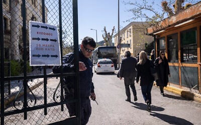 Un policier grec ferme l'entrée du tribunal après le transfert de suspects accusés d'appartenir à une organisation terroriste, à Athènes, le 20 mars 2023. Illustration. (Crédit : Petros Giannakouris/AP)