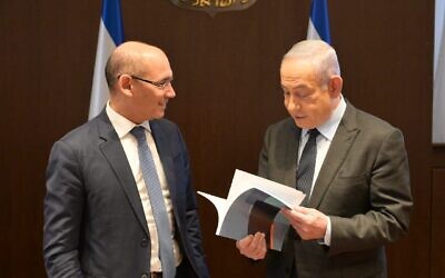 Le chef de la Banque d'Israël, Amir Yaron, à gauche, remet au Premier ministre Benjamin Netanyahu le rapport de fin d'année de la banque centrale à Jérusalem, le 28 mars 2024. (Crédit : Amos Ben-Gershom/GPO)