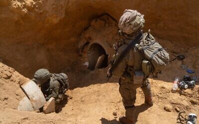 Des soldats israéliens à l'entrée d'un tunnel où les corps de cinq otages israéliens ont été détenus,  à Khan Younès,dans le sud de Gaza, 24 juillet 2024. (Crédit : Armée israélienne)