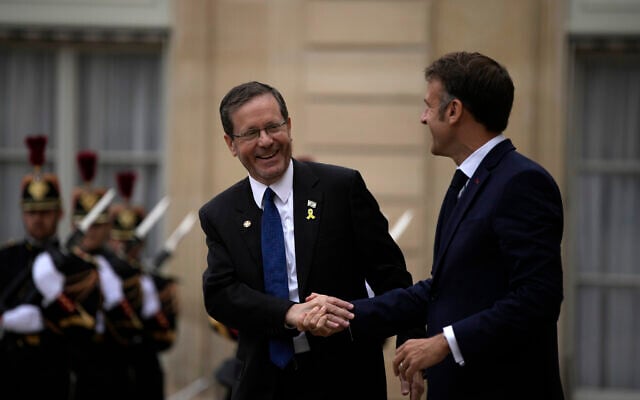 Le président français Emmanuel Macron, à droite, serre la main du président israélien Isaac Herzog après leur rencontre au Palais de l'Élysée, avant la cérémonie d'ouverture des Jeux olympiques d'été de 2024, le vendredi 26 juillet 2024, à Paris, en France. (Crédit : AP Photo/Louise Delmotte)