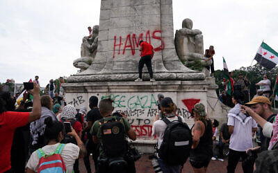 Des manifestations anti-Israël et pro-palestiniennes vandalisant la fontaine Christophe Colomb, à l'Union Station, à Washington, le 24 juillet 2024. (Crédit : Nathan Howard/Reuters)