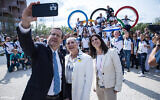 Le président Isaac Herzog, à gauche, sa femme Michal, au centre, et la cheffe du comité olympique israélien Yael Arad prennent un selfie avec des athlètes israéliens au village olympique de Paris, le 24 juillet 2024. (Crédit : Oded Karni/Comité olympique d'Israël)