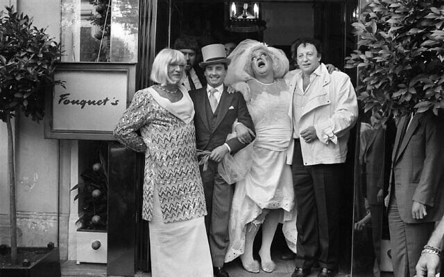 Les producteurs français Eddie Barclay (G) et Paul Lederman (D) assistent au faux mariage des humoristes français Thierry le Luron et Coluche, portant la robe de la mariée, le 25 septembre 1985 devant le restaurant Fouquet's à Paris. (Crédit : AFP/GEORGES BENDRIHEM) (Photo by GEORGES BENDRIHEM / AFP) Les producteurs français Eddie Barclay (G) et Paul Lederman (D) assistent au faux mariage des humoristes français Thierry le Luron et Coluche, portant la robe de la mariée, le 25 septembre 1985 devant le restaurant Fouquet's à Paris. (Crédit : AFP/GEORGES BENDRIHEM) (Photo by GEORGES BENDRIHEM / AFP)
