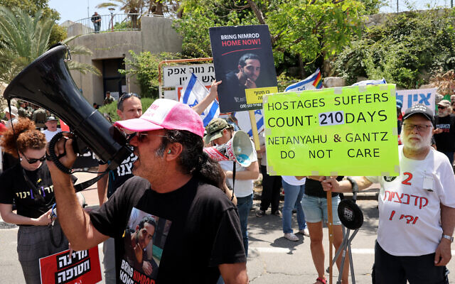 Yehuda Cohen porte un T-shirt avec une photo de son fils Nimrod Cohen pris en otage dans la bande de Gaza, lors d'un rassemblement près de la maison de l'ancien membre du Cabinet de guerre Benny Gantz, dans la ville centrale de Rosh Haayin, le 3 mai 2024, appelant le gouvernement à parvenir à un accord pour la libération de tous les otages. (Crédit : JACK GUEZ / AFP)