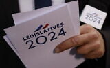 Un journaliste lors de la soirée électorale du parti au pouvoir Renaissance, alors que les résultats du premier tour des élections législatives sont attendus à Paris, le 30 juin 2024. (Crédit : Ludovic Marin/AFP)