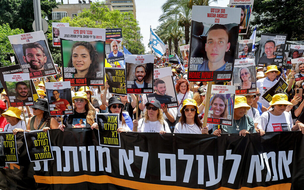 Des mères israéliennes et des militants participant à une marche de protestation pour marquer les neuf mois de la guerre entre Israël et le Hamas et pour la libération des Israéliens retenus en otage dans la bande de Gaza, à Tel Aviv, le 5 juillet 2024. Sur la banderole, on peut lire : "Une mère n'abandonne jamais : Une mère n'abandonne jamais. (Crédit : Jack Guez/AFP)