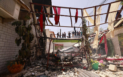 Des Palestiniens constatent les dommages infligés à une maison lors d'un raid israélien dans la ville de Jénine en Cisjordanie, le 5 juillet 2024. (Crédit : Jaafar Ashtiyeh / AFP)