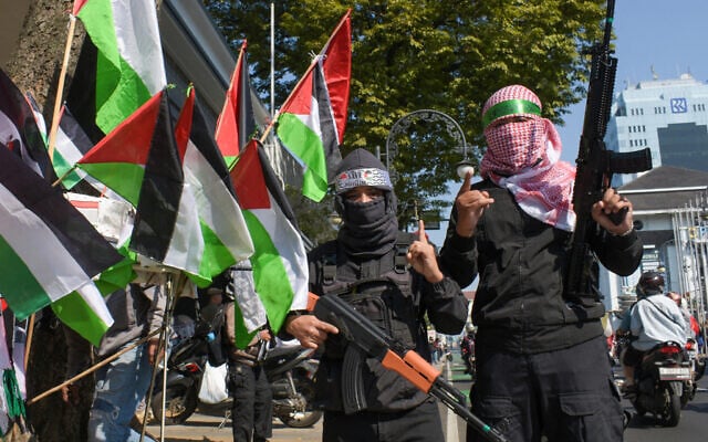 Des manifestants anti-Israël brandissant des drapeaux palestiniens et portent des bandeaux du Hamas alors qu'ils posent avec des armes jouets lors d'un rassemblement appelant au boycott des produits qu'ils considèrent comme soutenant Israël, à Bandung, Java Ouest, le 13 juillet 2024. (Crédit : Timur Matahari/AFP) Des manifestants anti-Israël brandissant des drapeaux palestiniens et portent des bandeaux du Hamas alors qu'ils posent avec des armes jouets lors d'un rassemblement appelant au boycott des produits qu'ils considèrent comme soutenant Israël, à Bandung, Java Ouest, le 13 juillet 2024. (Crédit : Timur Matahari/AFP)