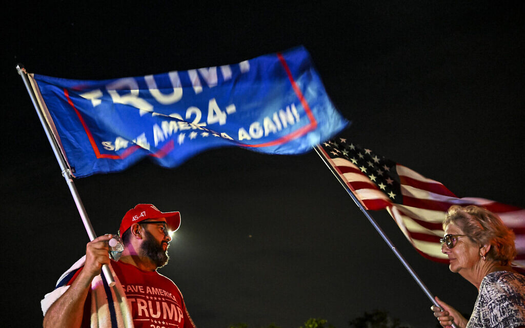 Des partisans de l'ancien président américain Donald Trump réunis aux abords de sa résidence de Mar-a-Lago après avoir entendu parler de la tentative d'assassinat apparente de Trump pendant son rassemblement de campagne à Butler, en Pennsylvanie, le 13 juillet 2024. (Crédit : CHANDAN KHANNA / AFP)
