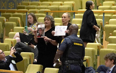 Des manifestants brandissent une photo d'un otage israélien et un panneau pendant une rencontre du Conseil de sécurité consacrée à la situation au Moyen-Orient, le 17 juillet 2024. (Crédit : Timothy A. Clary/AFP)