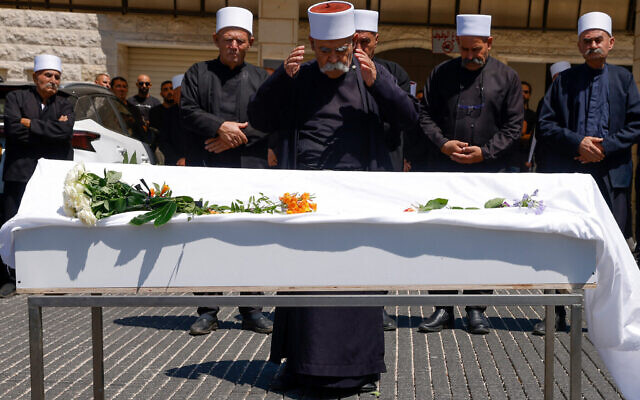 Des proches endeuillés et des anciens prient autour du cercueil de Gevara Ebraheem, 11 ans, tué dans une attaque à la roquette du Hezbollah dans la ville druze de Majdal Shams, le 29 juillet 2024. (Crédit : Jalaa MAREY / AFP)