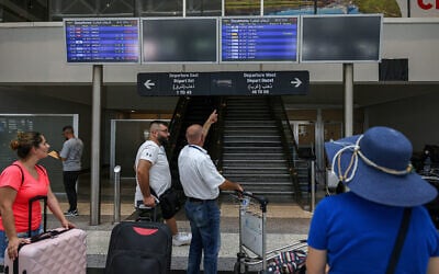 Des passagers regardant l'écran des horaires des vols à l'aéroport international Rafic Hariri après que leurs vols ont été retardés ou annulés, à Beyrouth, le 29 juillet 2024. (Crédit : Anwar Amro/AFP)