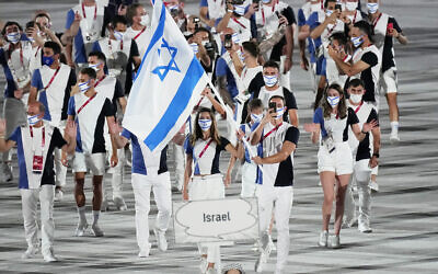 Les sportifs israéliens Hanna Minenko et Yakov Toumarkin portant le drapeau national lors de la cérémonie d'ouverture, dans le stade olympique des Jeux olympiques d'été de 2020, à Tokyo, au Japon, le 23 juillet 2021. (Crédit : David J. Phillip/AP)