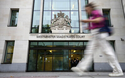 Illustration : Une femme passant devant le tribunal de première instance de Westminster, à Londres, le 17 août 2022. (Crédit : Frank Augstein/AP)