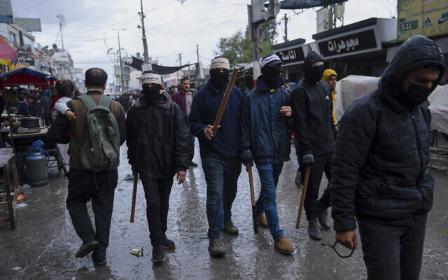 Photo d'illustration : Des membres masqués et armés des "Comités populaires de protection", créés par le Hamas et d'autres groupes terroristes, patrouillant dans les rues de la ville de Rafah, dans le sud de Gaza, le 7 mars 2024. (Crédit : AP Photo/Fatima Shbair)