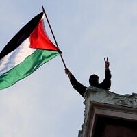 Un étudiant manifestant agitant un drapeau palestinien au-dessus du Hamilton Hall, sur le campus de l'Université Columbia, à New York, le 30 avril 2024. (Crédit : Mary Altaffer/AP/Pool)