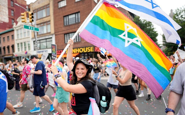 Une femme brandit un drapeau des Fiertés arc-en-ciel avec l'étoile de David pendant la Gay Pride de New York City, le 30 juin 2024. (Crédit : A Charles Sykes/Invision/AP)