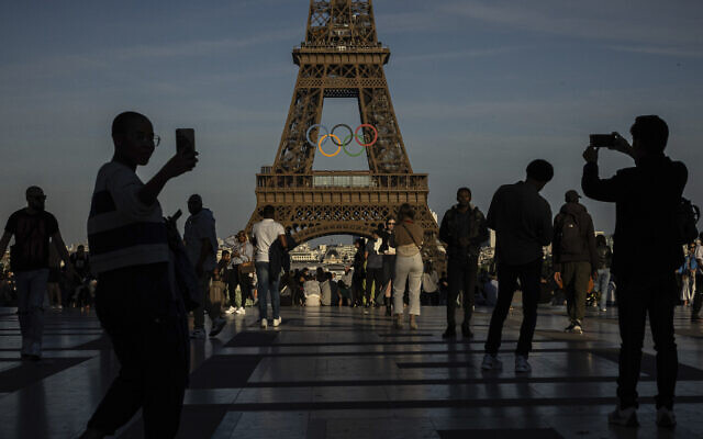 Des personnes photographiant les anneaux olympiques sur la Tour Eiffel, sur le parvis du Trocadéro, à Paris, le 7 juin 2024. (Crédit : Aurelien Morissard/AP) Des personnes photographiant les anneaux olympiques sur la Tour Eiffel, sur le parvis du Trocadéro, à Paris, le 7 juin 2024. (Crédit : Aurelien Morissard/AP)