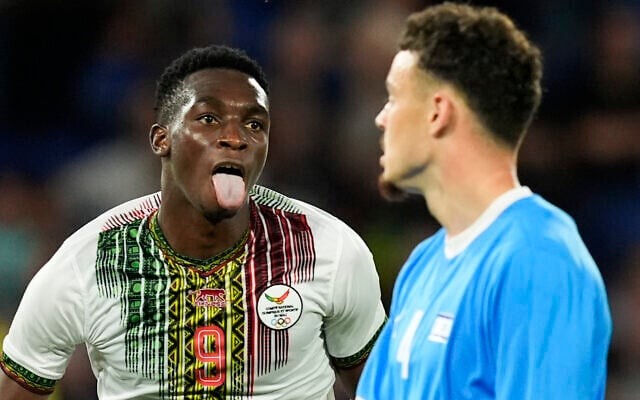 Cheickna Doumbia (à gauche) du Mali tirant la langue comme un enfant après avoir marqué le but de son équipe lors du match de foot masculin du groupe D entre Israël et le Mali au Parc des Princes lors des Jeux olympiques d'été de 2024, à Paris, en France, le 24 juillet 2024. (Crédit : Rebecca Blackwell/AP) Cheickna Doumbia (à gauche) du Mali tirant la langue comme un enfant après avoir marqué le but de son équipe lors du match de foot masculin du groupe D entre Israël et le Mali au Parc des Princes lors des Jeux olympiques d'été de 2024, à Paris, en France, le 24 juillet 2024. (Crédit : Rebecca Blackwell/AP)