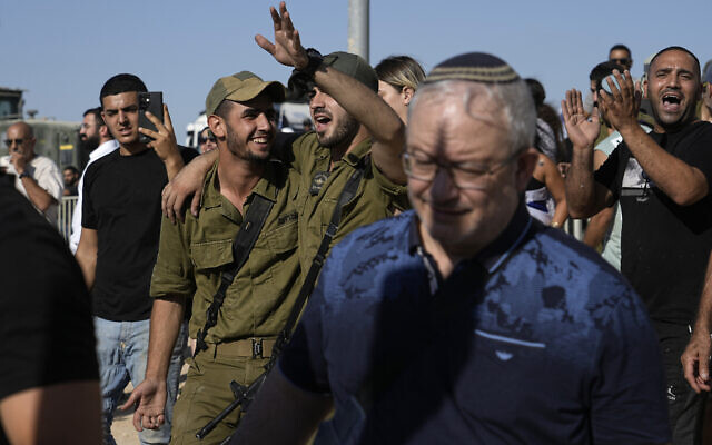 Des soldats israéliens et d'autres activistes manifestent à la porte de la base militaire de Sde Teiman, près de Beer Sheva, en soutien à des militaires de la base interrogés dans le cadre d'une enquête sur des violences commises sur un terroriste présumé palestinien qui était incarcéré là-bas, le 29 juillet 2024. (Crédit : AP/Tsafrir Abayov) Des soldats israéliens et d'autres activistes manifestent à la porte de la base militaire de Sde Teiman, près de Beer Sheva, en soutien à des militaires de la base interrogés dans le cadre d'une enquête sur des violences commises sur un terroriste présumé palestinien qui était incarcéré là-bas, le 29 juillet 2024. (Crédit : AP/Tsafrir Abayov)