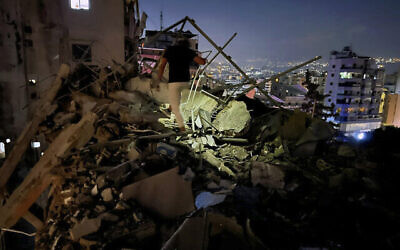 Un homme inspectant un bâtiment détruit par une frappe aérienne israélienne dans la banlieue sud de Beyrouth, au Liban, le 30 juillet 2024. (Crédit : Hussein Malla/AP)
