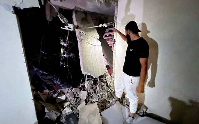 Un homme inspectant les dégâts causés par une frappe aérienne israélienne dans la banlieue sud de Beyrouth, au Liban, le 30 juillet 2024. (Crédit : Hussein Malla/AP) Un homme inspectant les dégâts causés par une frappe aérienne israélienne dans la banlieue sud de Beyrouth, au Liban, le 30 juillet 2024. (Crédit : Hussein Malla/AP)