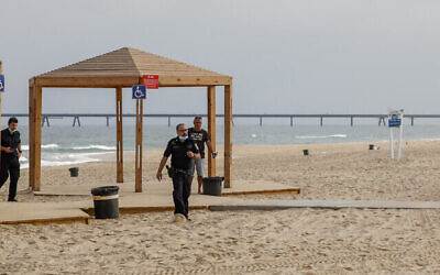 Des policiers israéliens marchent sur la plage de Zikim, près de la frontière de Gaza, après qu'elle a été fermée aux visiteurs, le 24 avril 2021. (Crédit : Flash90)