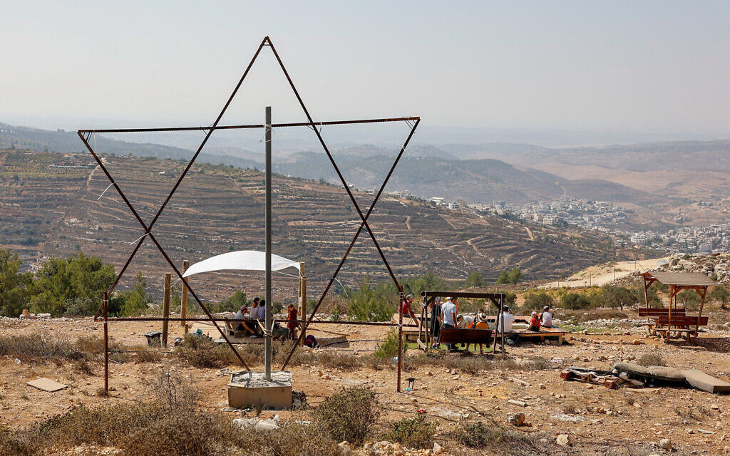 Des Israéliens célébrant la fête de Souccot devant une grande étoile de David, dans l'implantation de Sde Boaz, dans le Gush Etzion, le 11 octobre 2022. (Crédit : Gershon Elinson/Flash90) Des Israéliens célébrant la fête de Souccot devant une grande étoile de David, dans l'implantation de Sde Boaz, dans le Gush Etzion, le 11 octobre 2022. (Crédit : Gershon Elinson/Flash90)