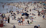 Illustration : Des Israéliens profitant de la plage lors d'une vague de chaleur, à Tel Aviv, le 24 avril 2024. Crédit : Avshalom Sassoni/Flash90)
