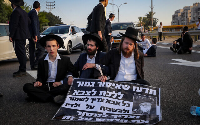 Des hommes ultra-orthodoxes protestant contre l'appel sous les drapeaux, sur la Route 4, à l'extérieur de Bnei Brak, le 16 juillet 2024. (Crédit : Jamal Awad/Flash90)