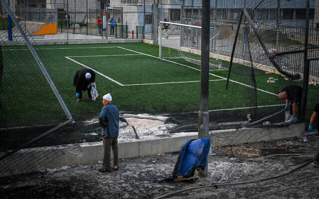 Les secouristes israéliens sur le site d'une attaque à la roquette du Hezbollah sur un terrain de football dans la ville de Majdal Shams, au nord du Golan, le 27 juillet 2024. (Crédit : Michael Giladi/Flash90)
