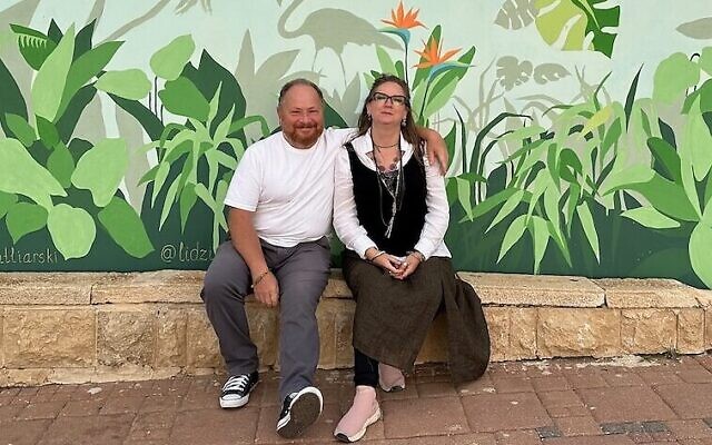 Lidia Katliarski et son mari et collaborateur, Igor Katliarski, devant l'un de leurs abris anti-bombes peints, à Nahariya, au printemps 2024. (Crédit : Lidia Katliarski)