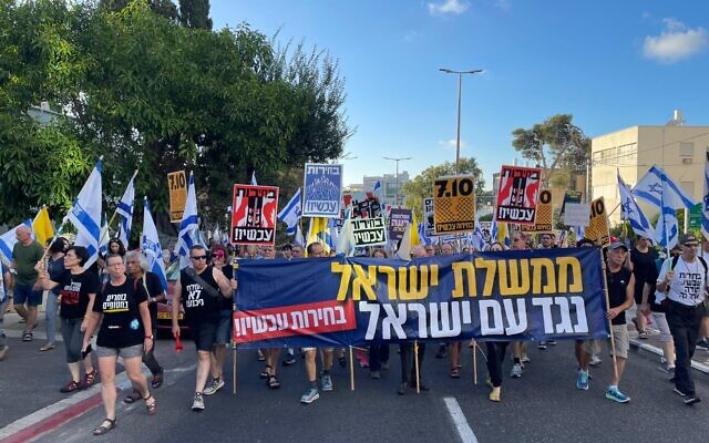 Des manifestants anti-gouvernement défilant, avec une banderole sur laquelle on peut lire : "Le gouvernement d'Israël contre le peuple d'Israël. Des élections maintenant", dans la ville de Haïfa, au nord du pays, le 6 juillet 2024. (Crédit : Eilat Markovitch/Mouvement de protestation pour la démocratie) Des manifestants anti-gouvernement défilant, avec une banderole sur laquelle on peut lire : "Le gouvernement d'Israël contre le peuple d'Israël. Des élections maintenant", dans la ville de Haïfa, au nord du pays, le 6 juillet 2024. (Crédit : Eilat Markovitch/Mouvement de protestation pour la démocratie)
